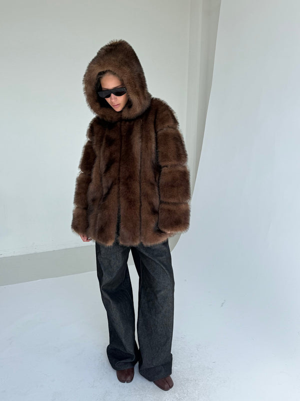 A model wearing a luxurious brown fur hooded coat paired with wide-leg dark jeans, showcasing MEOTINE's stylish winter collection.