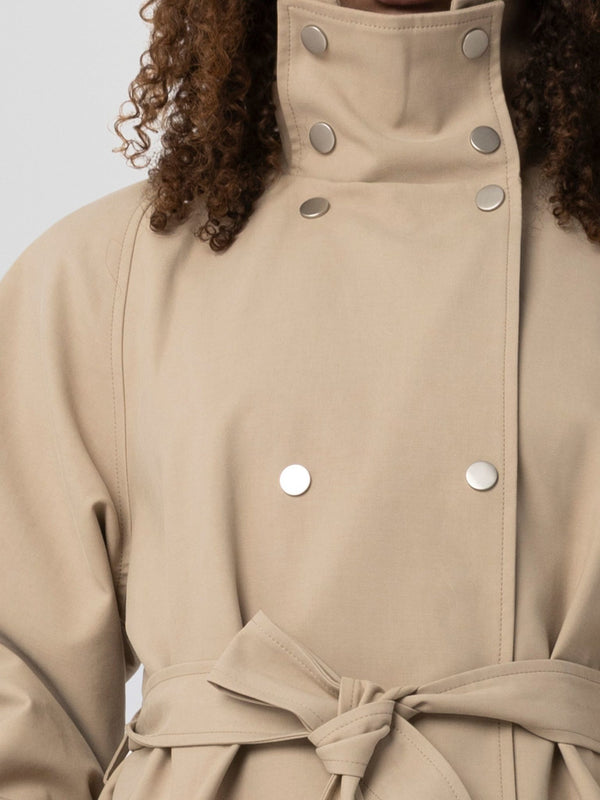Beige trench coat with a belted waist and silver snap buttons, showcasing a stylish and modern design by MEOTINE.