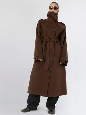 A model showcases a stylish brown trench coat with a high collar and belt, paired with black pants and sunglasses, by MEOTINE.