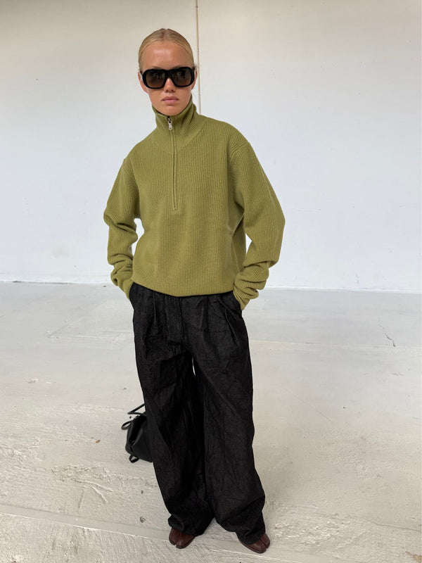 A model showcases a stylish olive green zip-up sweater paired with black wide-leg pants, embodying a chic MEOTINE look.