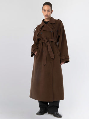 A model showcases a brown oversized trench coat with a belt, featuring a classic design and relaxed fit, by MEOTINE.