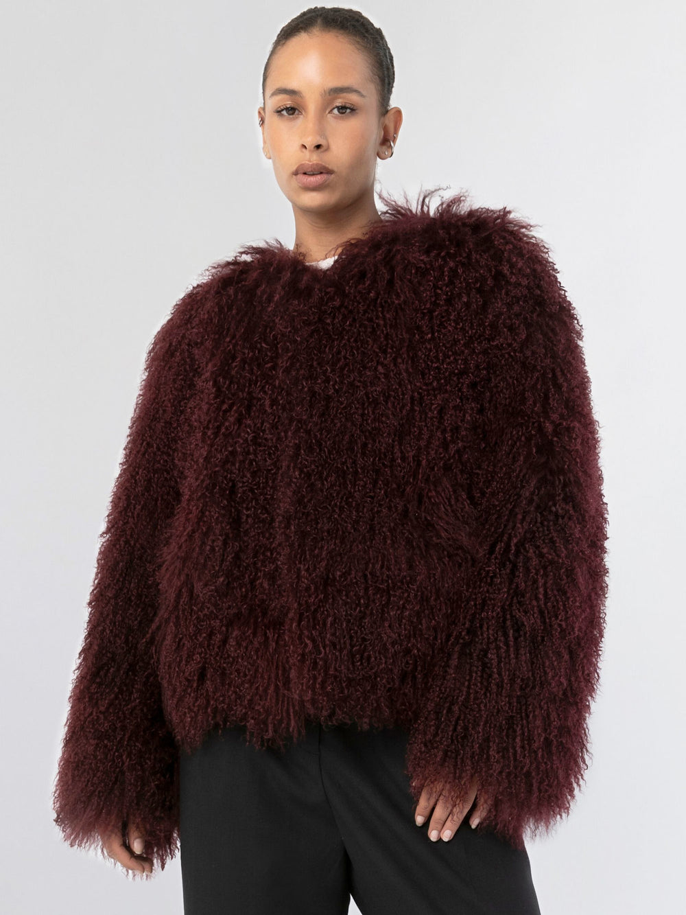 A model showcases a plush, burgundy MEOTINE faux fur jacket with a relaxed fit and long sleeves, perfect for cozy styling.