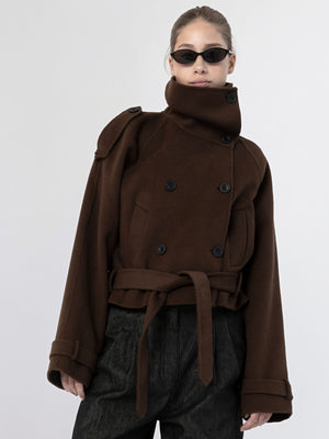 A model showcases a stylish brown double-breasted coat with a high collar and belted waist, complemented by sleek sunglasses. MEOTINE.