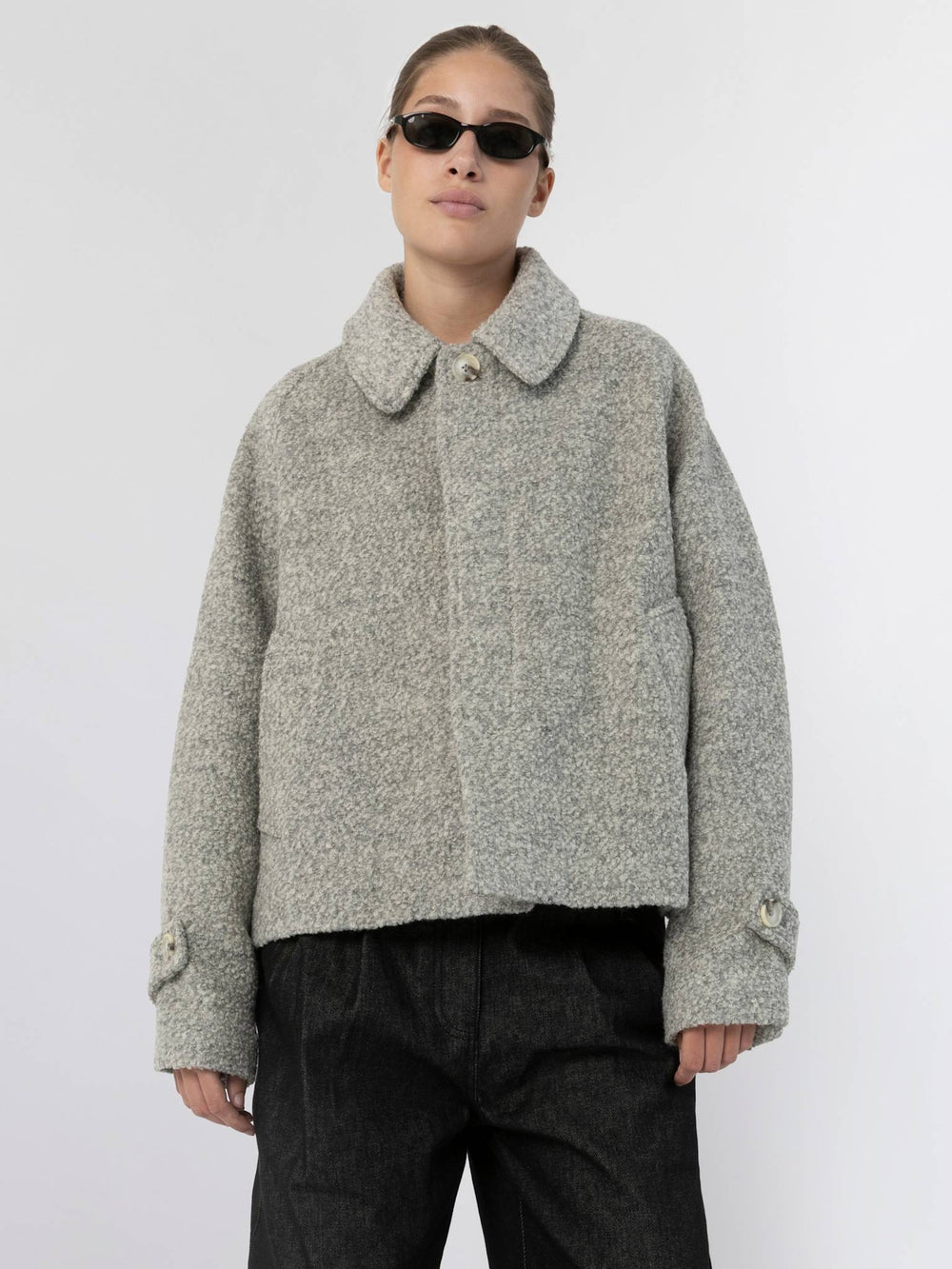 A model wearing a stylish gray MEOTINE jacket with a collared neckline, paired with black wide-leg pants and sunglasses.