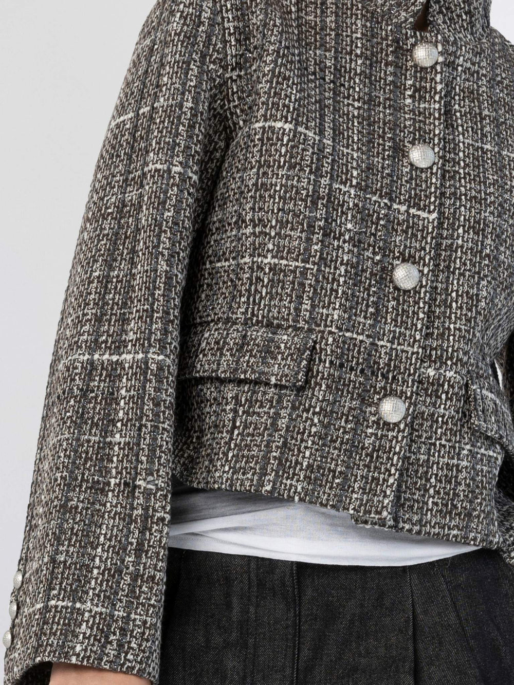 Chic cropped jacket in black and white tweed with large buttons, paired with relaxed dark trousers and stylish sunglasses. MEOTINE.