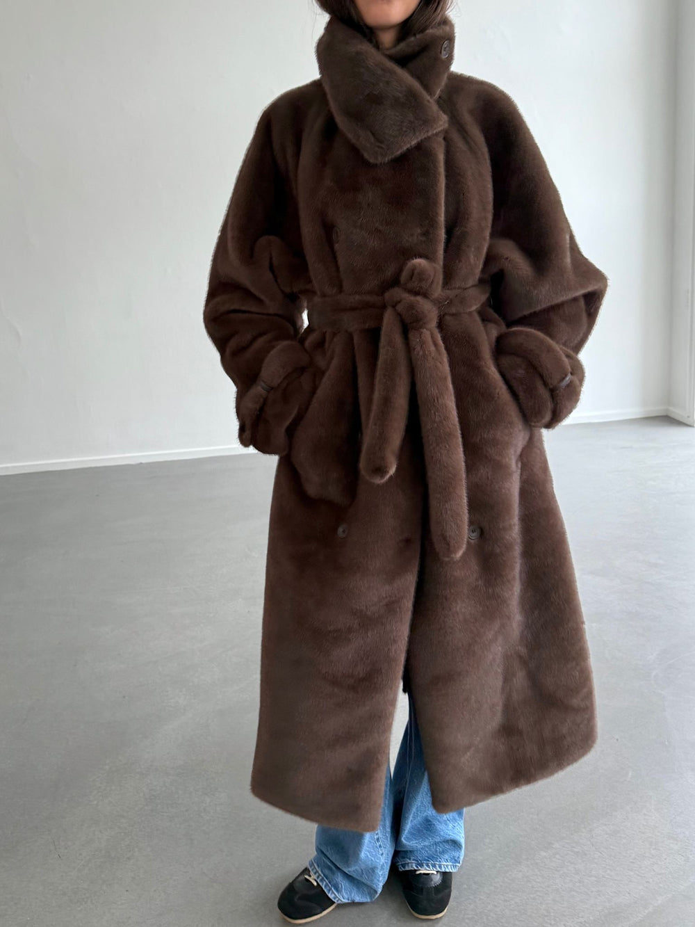 Luxurious brown faux fur coat with a belted waist and oversized collar, perfect for stylish warmth this season by MEOTINE.