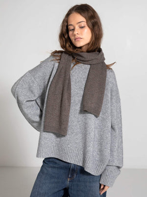 A model wears a cozy gray oversized sweater paired with a brown scarf, showcasing MEOTINE's stylish winter collection.