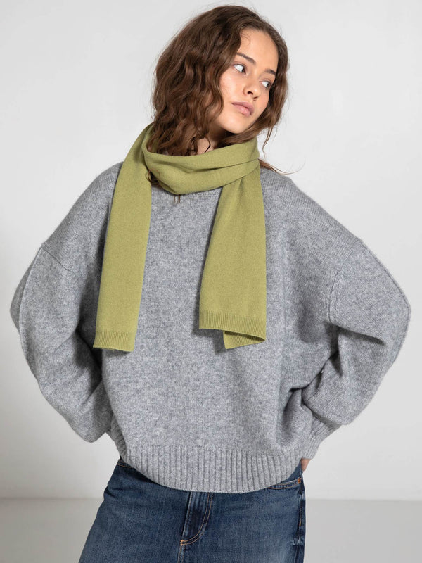 A model wears a cozy gray oversized sweater paired with a soft green scarf, showcasing MEOTINE's stylish winter collection.