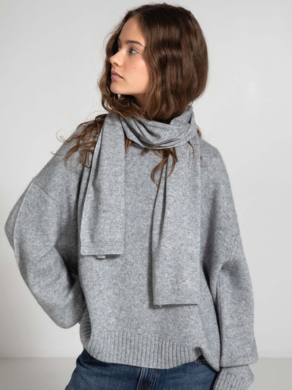 Cozy gray oversized sweater with a matching scarf, styled casually with relaxed jeans, showcasing MEOTINE's chic comfort.