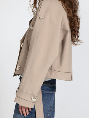 Stylish beige cropped jacket with large buttons, featuring a relaxed fit and side tie detail, perfect for a trendy look by MEOTINE.