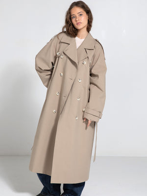 A model poses in a stylish beige trench coat with a relaxed fit, showcasing MEOTINE's contemporary design and elegance.