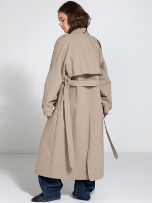 A model showcases a stylish beige trench coat with a belted waist, designed by MEOTINE, perfect for a chic, modern look.