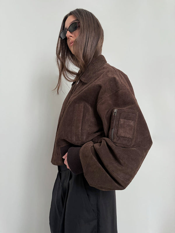 Stylish brown cropped jacket with oversized sleeves, paired with sleek black pants and sunglasses, showcasing MEOTINE's modern design.