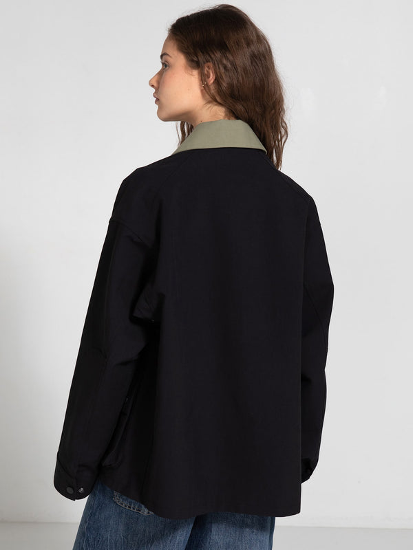 A model showcases a stylish oversized black jacket with a contrasting green collar, embodying MEOTINE's modern aesthetic.