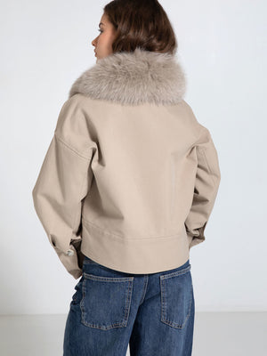 Stylish beige jacket with a luxurious fur collar, paired with denim jeans, showcasing a chic and modern look by MEOTINE.