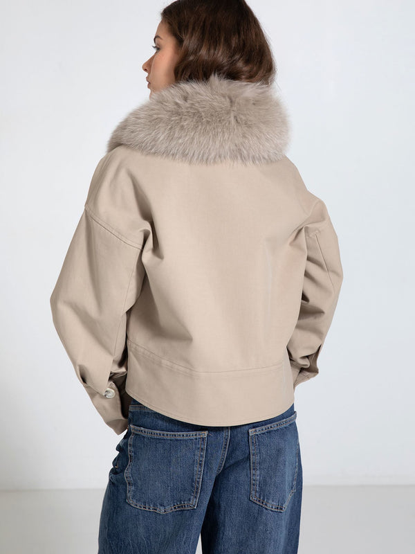 Stylish beige jacket with a luxurious fur collar, paired with denim jeans, showcasing a chic and modern look by MEOTINE.