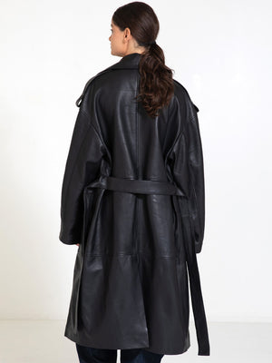 A model showcases a stylish black leather trench coat with a belted waist, exuding elegance and sophistication by MEOTINE.
