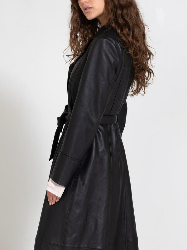 A model showcases a stylish black leather coat with a belted waist, exuding elegance and sophistication by MEOTINE.