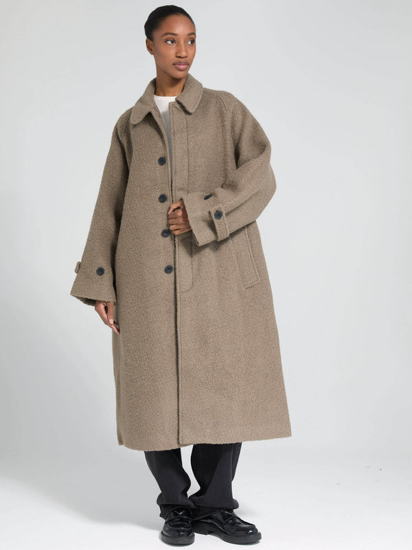 A model showcases a cozy, oversized beige coat with large buttons and a relaxed fit, perfect for stylish warmth by MEOTINE.