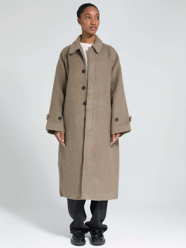 A model showcases a cozy, oversized beige coat with a button front and wide sleeves, embodying MEOTINE's stylish comfort.