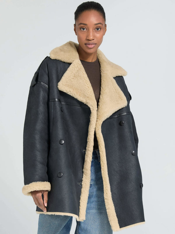 Stylish black oversized coat with a plush beige collar, perfect for a chic winter look. By MEOTINE.