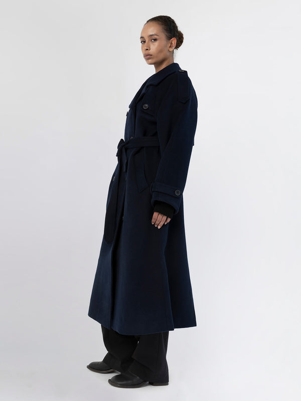 A model showcases a stylish navy blue trench coat with a belt, featuring a tailored fit and elegant design by MEOTINE.
