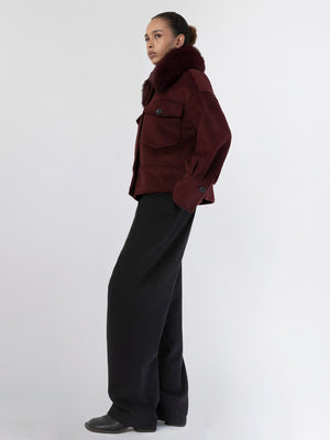 A model showcases a stylish burgundy jacket with a fur collar, paired with wide-leg black trousers, embodying MEOTINE's chic aesthetic.