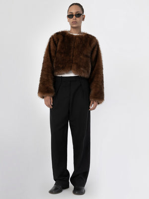 A model wears a brown faux fur cropped jacket paired with black wide-leg trousers, showcasing MEOTINE's stylish winter collection.