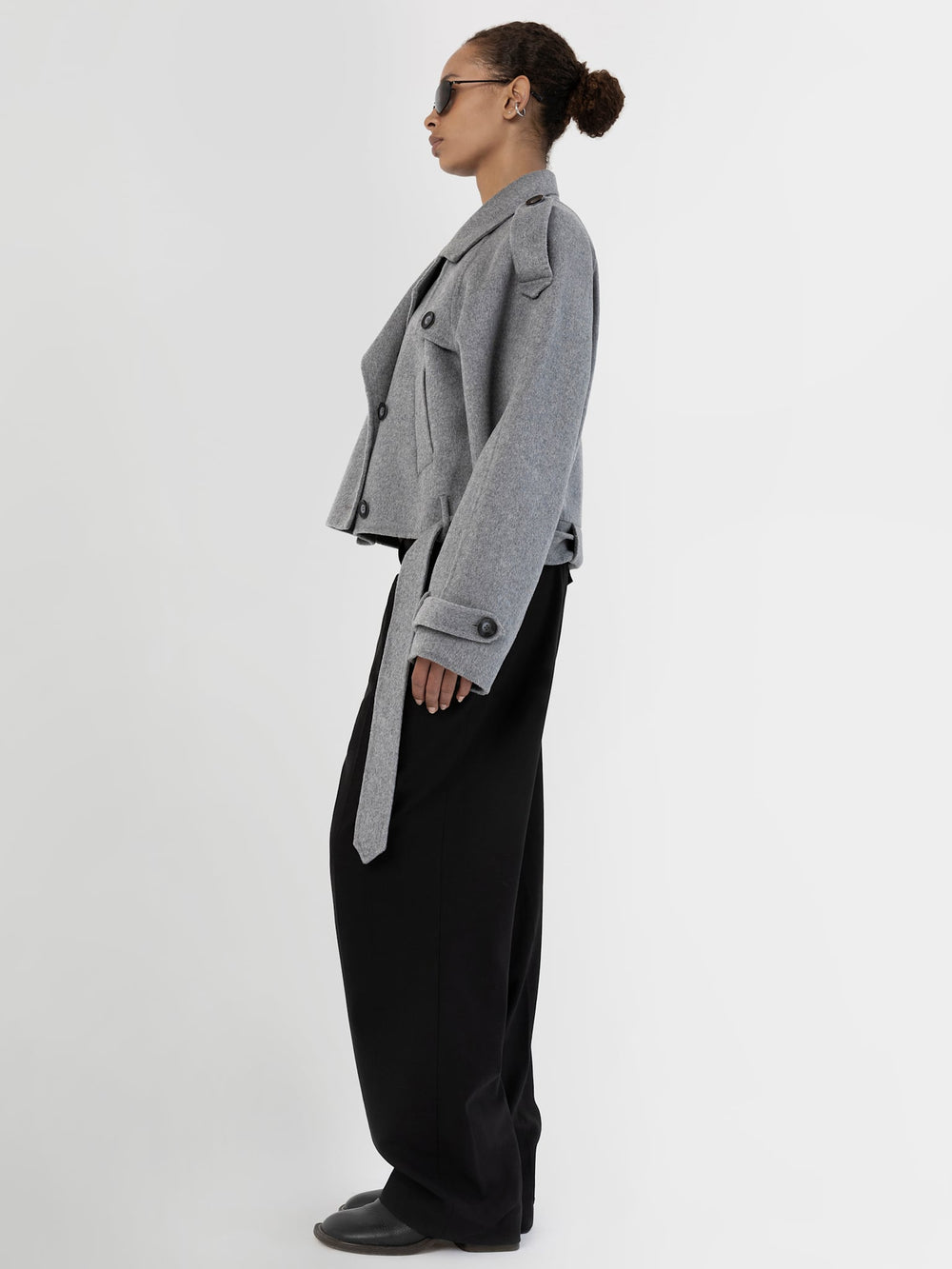 Stylish gray cropped trench coat with double-breasted buttons, paired with sleek black pants and sunglasses, by MEOTINE.