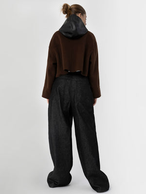 A model showcases a stylish brown cropped sweater with a black hood, paired with loose black trousers, representing MEOTINE's modern aesthetic.