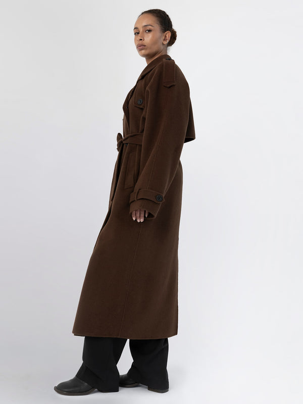 A model showcases a stylish brown long coat with a belt, featuring a classic design, perfect for a chic look by MEOTINE.