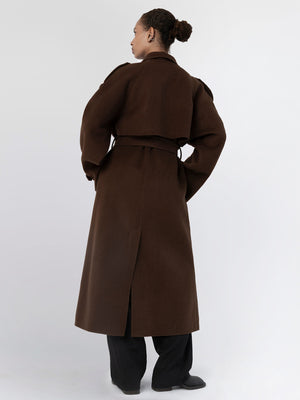 A model showcases a stylish brown trench coat from MEOTINE, featuring a belted waist and a sleek, long silhouette.