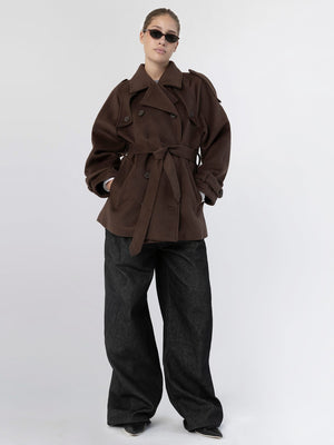 A model wears a stylish brown oversized trench coat with a belt, paired with wide-leg black pants and sunglasses, showcasing MEOTINE's chic design.