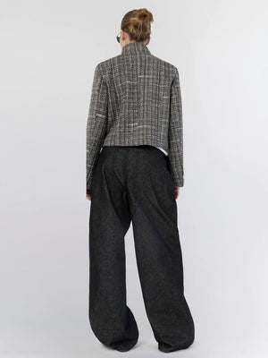Stylish back view of a model wearing a cropped, textured jacket paired with loose, dark trousers by MEOTINE.