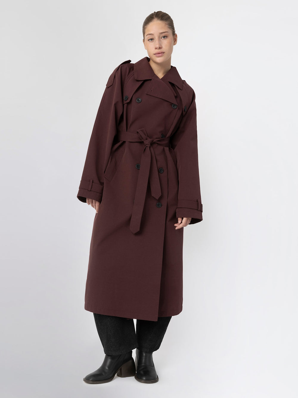 Stylish burgundy trench coat with a belted waist and double-breasted buttons, perfect for a chic look by MEOTINE.