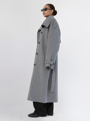 A model showcases a stylish gray overcoat with a high collar and buttons, paired with sleek sunglasses, embodying MEOTINE's chic aesthetic.