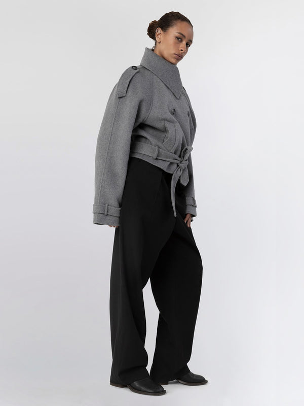 A model showcases a stylish gray oversized jacket with a belted waist, paired with wide-leg black trousers, embodying MEOTINE's chic aesthetic.