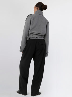 A model showcases a stylish gray MEOTINE jacket paired with black wide-leg trousers, highlighting a modern, chic look from the back.
