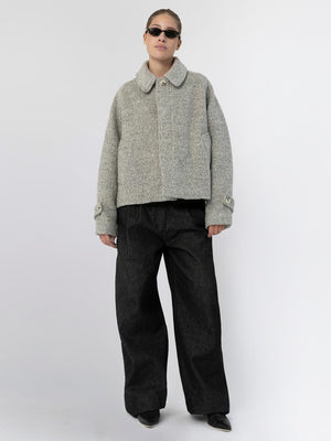 A model wears a cozy grey MEOTINE jacket paired with wide black trousers, showcasing a stylish and relaxed look.