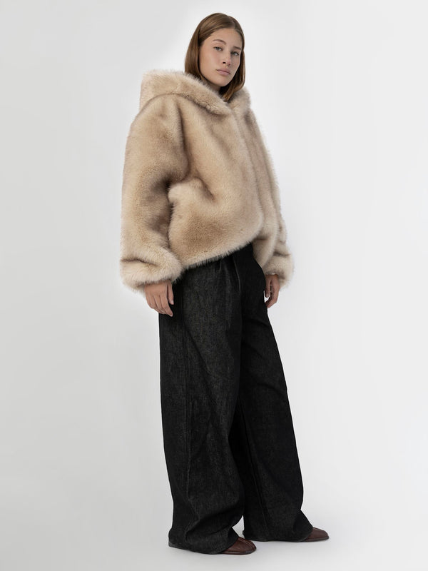 Cozy beige faux fur hoodie paired with wide-leg black pants, showcasing a stylish and modern look by MEOTINE.