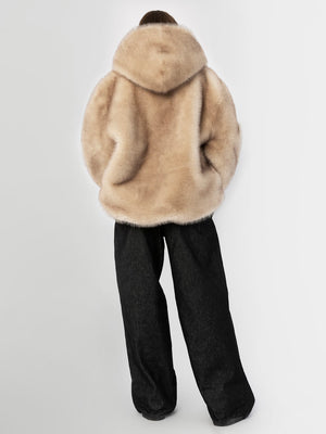 Cozy beige faux fur jacket with a hood, paired with loose black trousers, showcasing a stylish and comfortable look by MEOTINE.