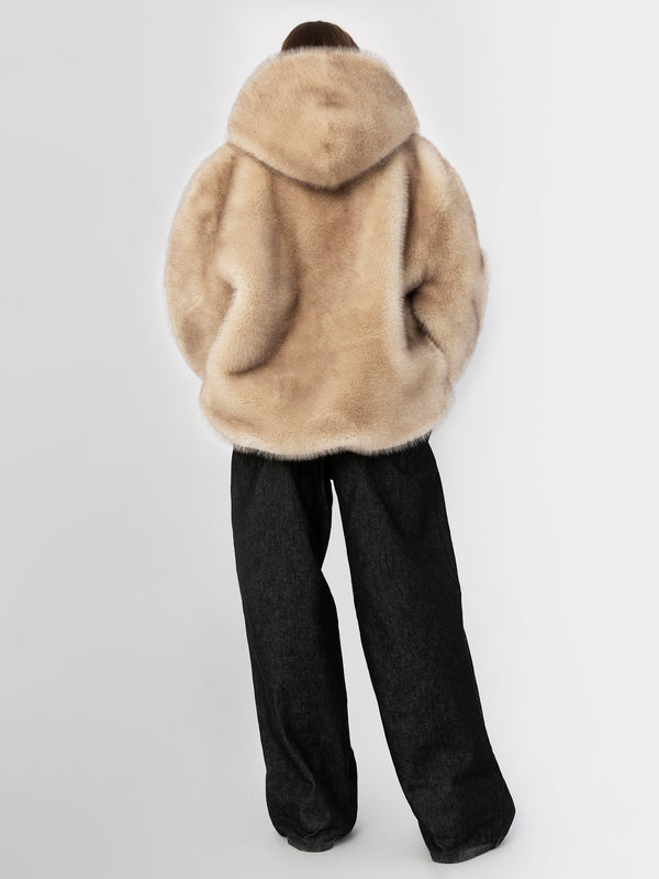 Cozy beige faux fur jacket with a hood, paired with loose black trousers, showcasing a stylish and comfortable look by MEOTINE.
