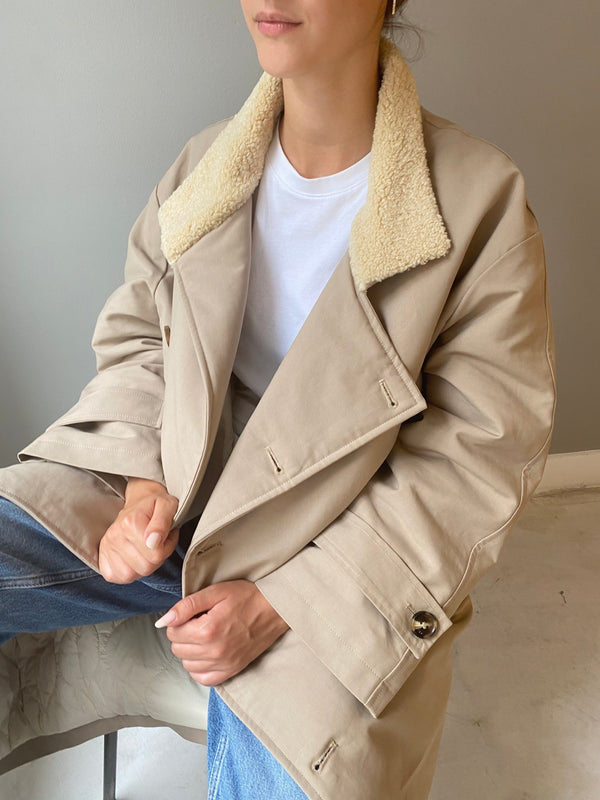 Cozy beige MEOTINE coat with a soft shearling collar, styled over a white t-shirt, perfect for a chic, casual look.