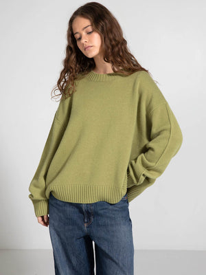 Oversized green sweater with a relaxed fit, paired with loose denim jeans, showcasing a casual style by MEOTINE.