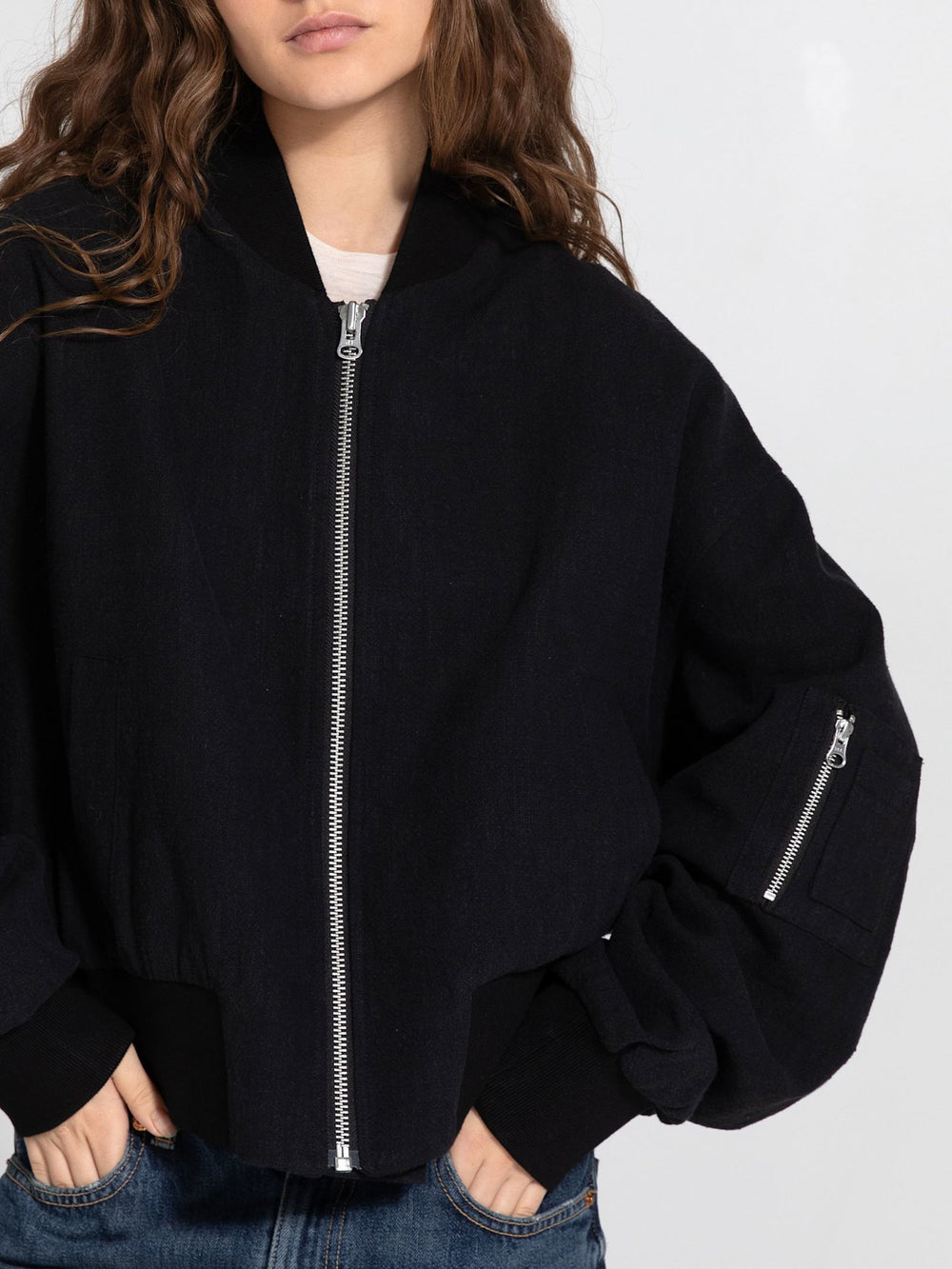 A model wears a stylish black cropped jacket with oversized sleeves, showcasing a modern look by MEOTINE.
