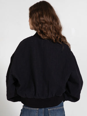 Black oversized bomber jacket with a ribbed hem, featuring a relaxed fit and voluminous sleeves, perfect for a stylish look by MEOTINE.