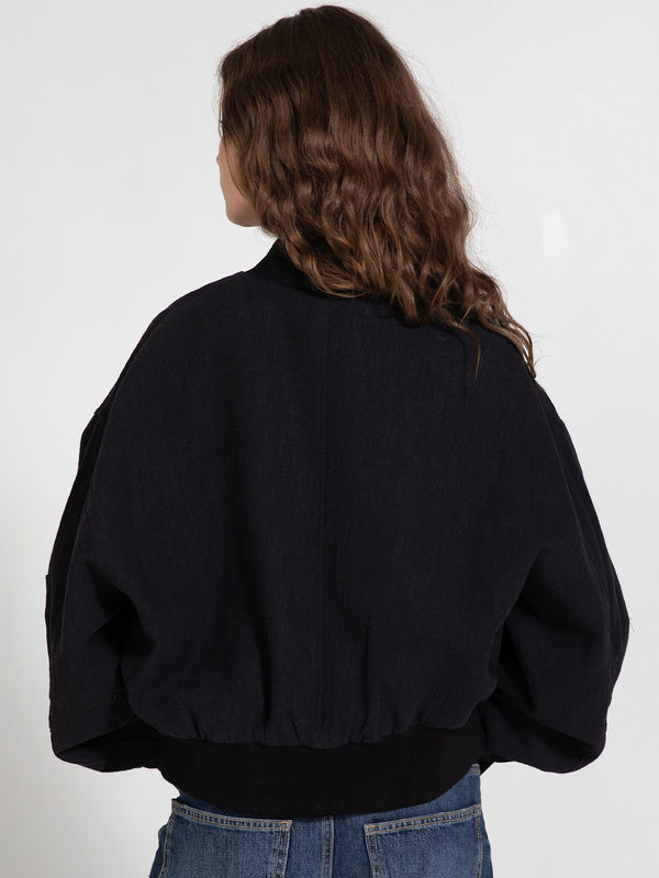 Black oversized bomber jacket with a ribbed hem, featuring a relaxed fit and voluminous sleeves, perfect for a stylish look by MEOTINE.