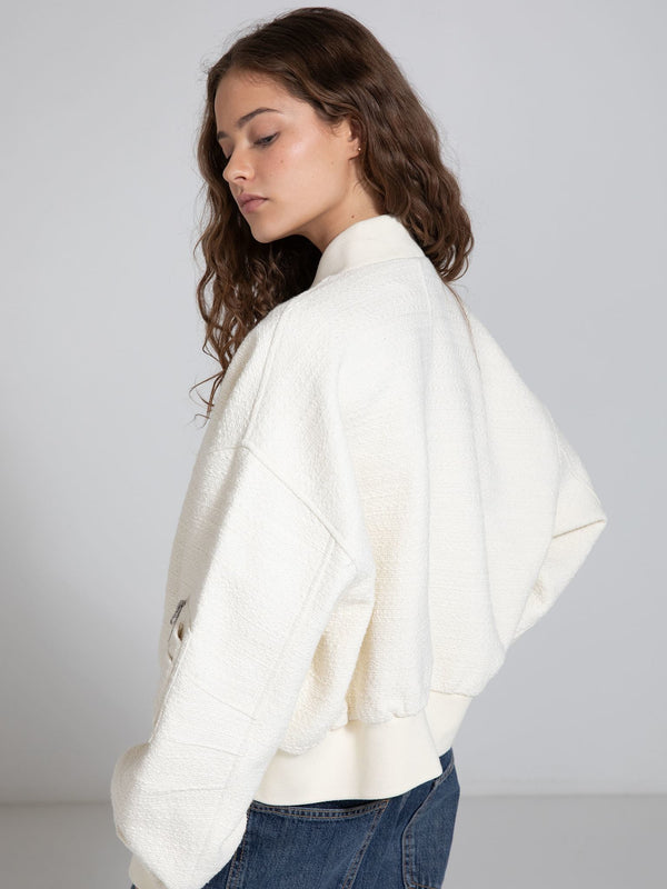 A model showcases a cozy, oversized cream jacket with a textured finish, styled with casual denim, embodying MEOTINE's chic aesthetic.