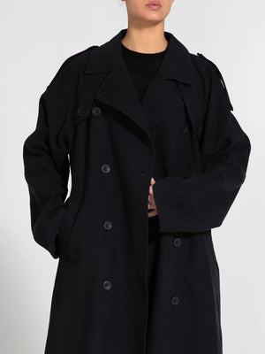 A model wears a stylish black trench coat with a relaxed fit and double-breasted buttons, showcasing MEOTINE's modern design.