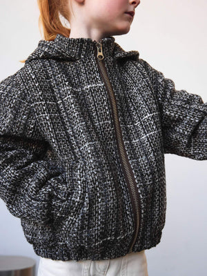 Stylish black and white textured jacket with a hood, perfect for kids, featuring a zip closure and side pockets by MEOTINE.